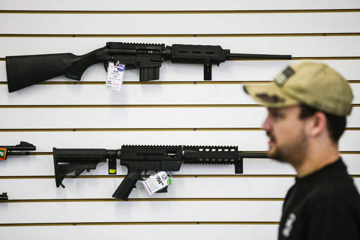 A sales associate walks past semiautomatic rifles at Bullseye Sport gun shop in Riverside, Calif., on Dec. 9, 2015. (Jae C. Hong/AP Photo)