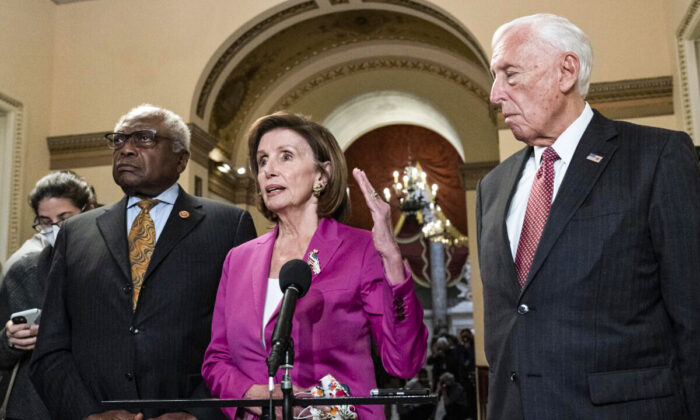 Speaker of the House Nancy Pelosi (D-Calif.), accompanied by House Majority Whip James Clyburn, (D-S.C.)(L) and House Majority Leader Steny Hoyer (D-Md.), speaks to reporters at the Capitol in Washington on Nov. 5, 2021. (Jose Luis Magana/AP Photo)