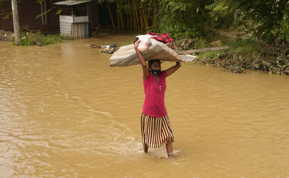 A Sri Lankan woman wades through a flooded area in Kochchikade, about 30 kilometers north of Colombo, Sri Lanka, on Nov. 10, 2021. (Eranga Jayawardena/AP Photo)