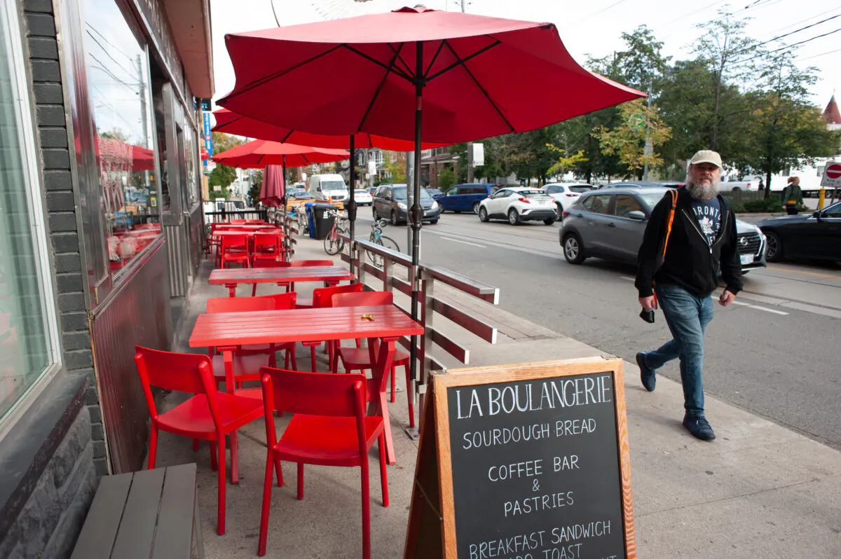 A man walks by the empty patio of a restaurant on Dundas St. in Toronto, on Oct. 28, 2021. (The Canadian Press/Eduardo Lima) 