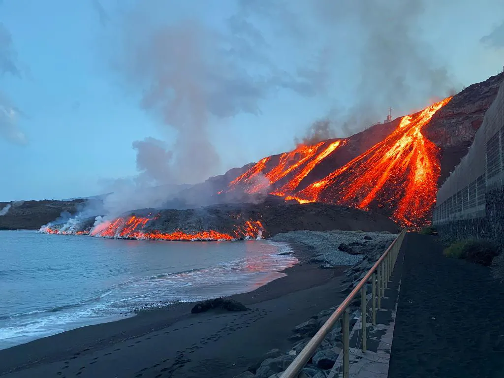 Lava spewed by Cumbre Vieja volcano reaches the Atlantic Ocean at Los Guirres beach on the Canary Island of La Palma, Spain, on Nov. 10, 2021. (Spanish Transport Ministry/Handout via Reuters)