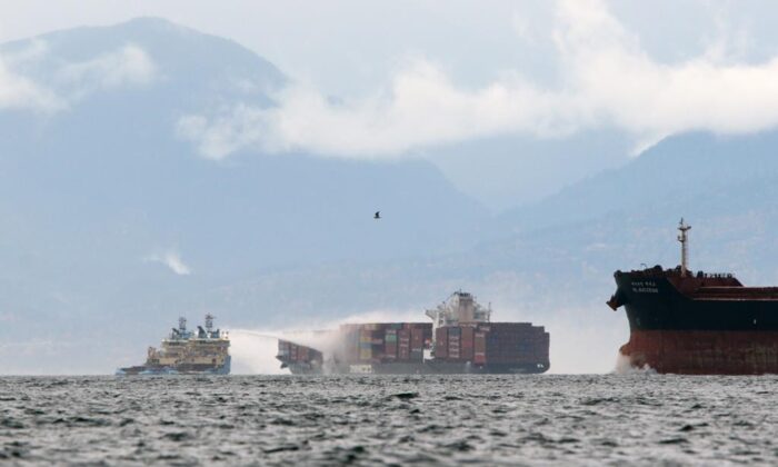 The ship is working to control the fire on October 24, 2021 on the MV Zim Kingston, about 8 km from the coast of Victoria, British Columbia. The container ship ignited on Saturday and 16 crew members were evacuated and taken to Ogden Point Wharf.  (Canadian Press / Chad Hippolyto)