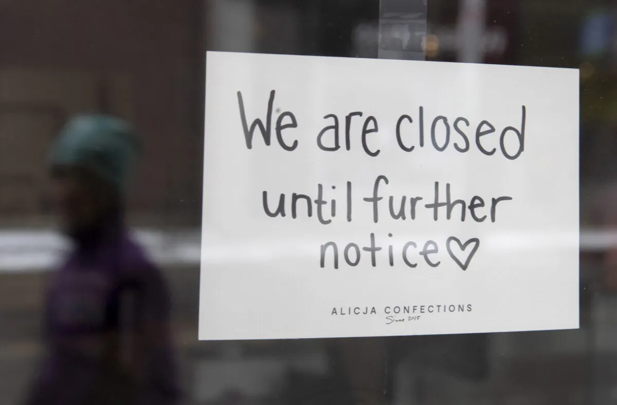 A sign on a shop window indicates the store is closed in Ottawa, on March 23, 2020. (Adrian Wyld/The Canadian Press)