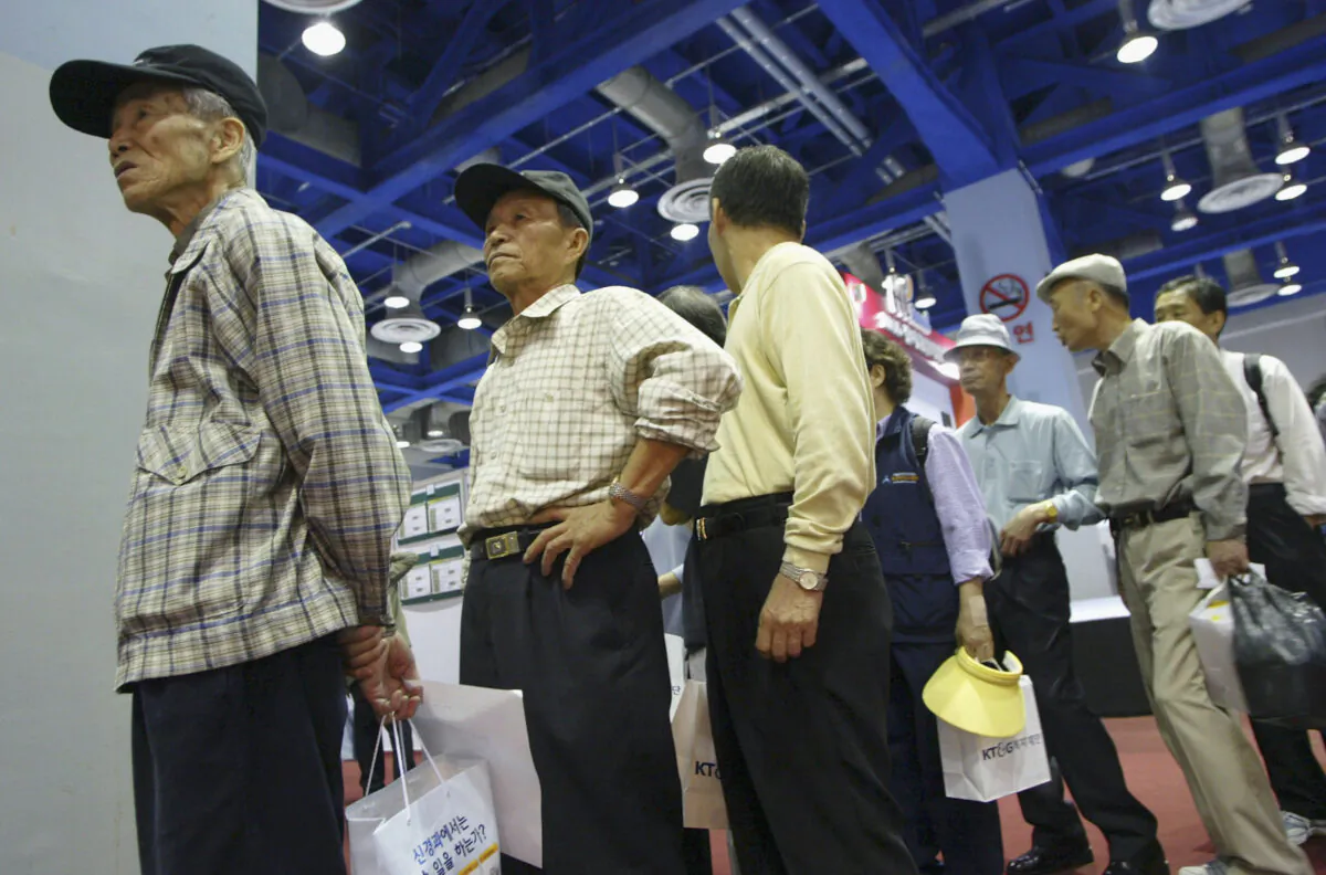 Elderly South Korean job seekers line up for interview during an elderly persons' job fair, in Seoul, on Sept. 23, 2005. (Chung Sung-Jun/Getty Images)