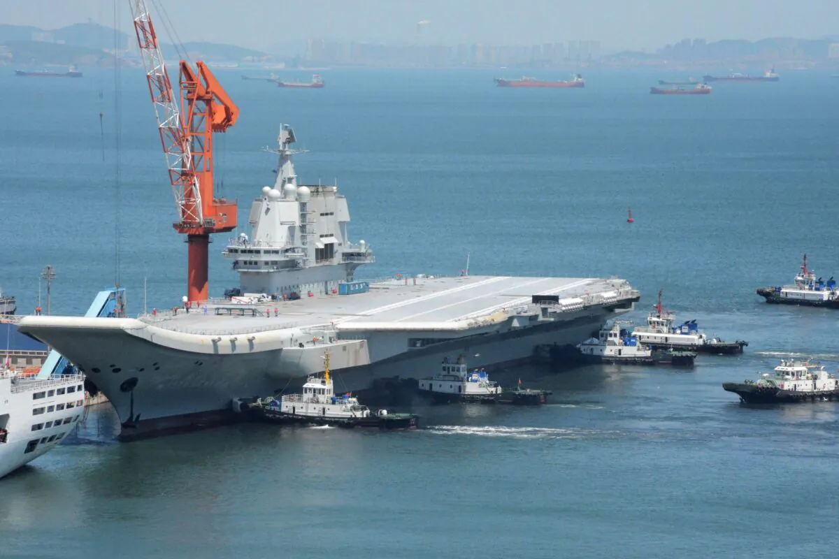 Tugs guide China's first domestically manufactured aircraft carrier, known as "Type 001A," as it returns to port in Dalian in China's northeastern Liaoning province after its first sea trial, on May 18, 2018.  (AFP via Getty Images)