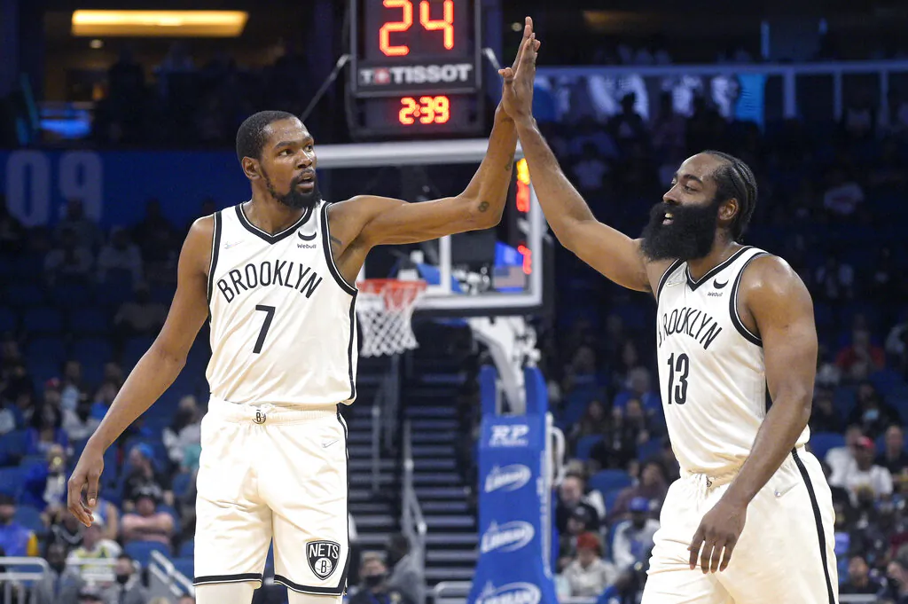 Brooklyn Nets forward Kevin Durant (7) and guard James Harden (13) high-five after a basket during the first half of the team's NBA basketball game against the Orlando Magic,    in Orlando, Fla., on Nov. 10, 2021. (Phelan M. Ebenhack/AP Photo)