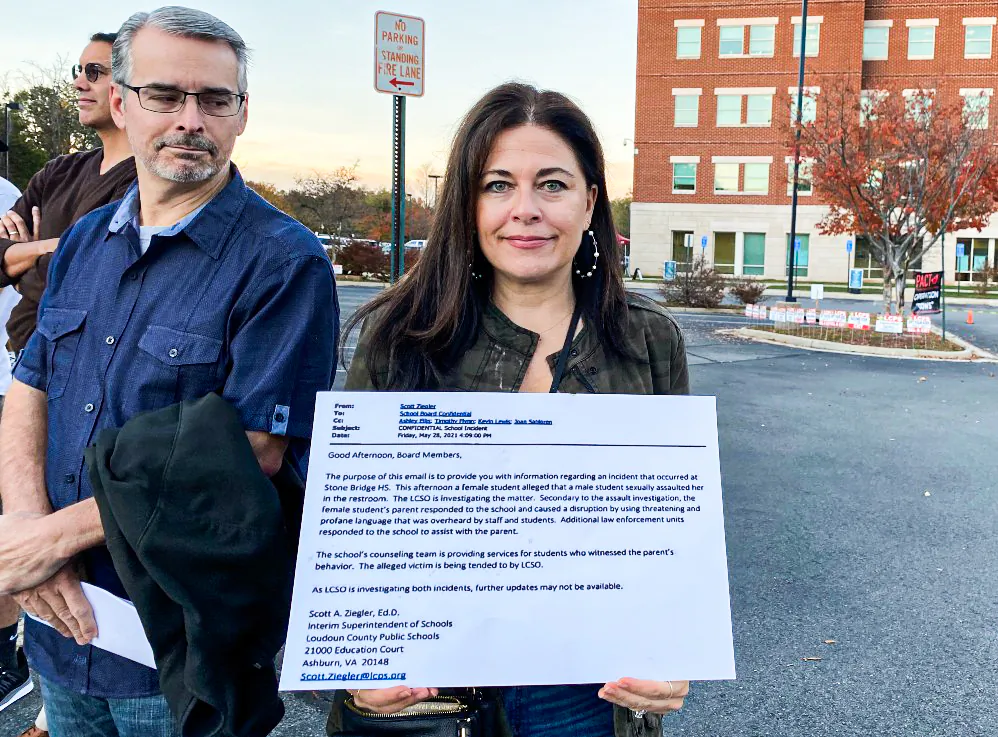 A Loudoun County resident holds a sign of Loudoun County Public Schools (LCPS) Superintendent Scott Ziegler’s email on May 28, 2021—notifying the school board of a sexual assault case in a high school bathroom—outside the LCPS administration building in Ashburn, Va., on Nov. 9, 2021. During a June 22 school board meeting discussion on LCPS pro-transgender policy, Ziegler said he wasn’t aware of sexual assaults in school bathrooms. (Terri Wu/The Epoch Times)