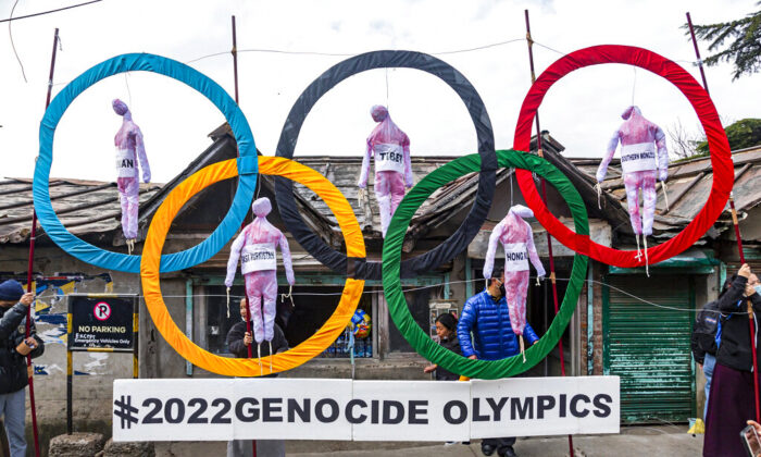 Exiled Tibetans use the Olympic Rings as a prop as they hold a street protest against the holding of 2022 Winter Olympics in Beijing, in Dharmsala, India, on Feb. 3, 2021. (Ashwini Bhatia/AP Photo)