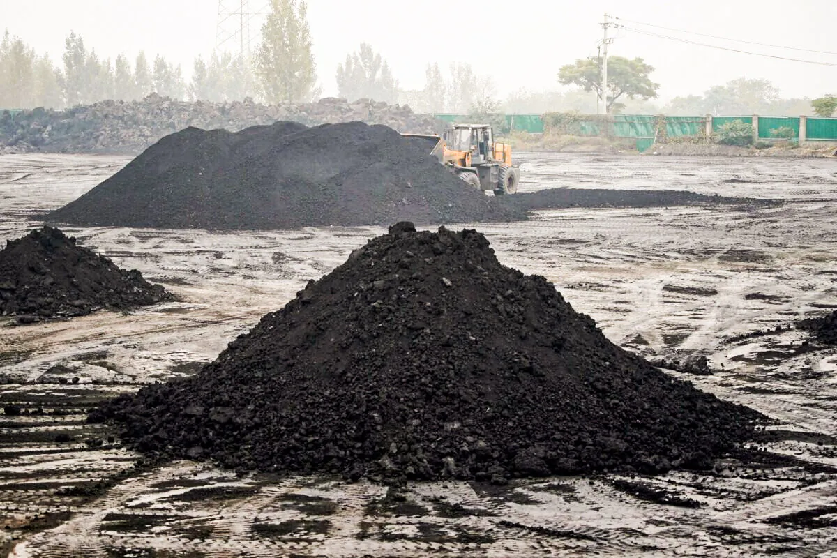 An excavator sift through dunes of low-grade coal near a coal mine in Pingdingshan, Henan province, China, on Nov. 5, 2021. (Aly Song/Reuters)
