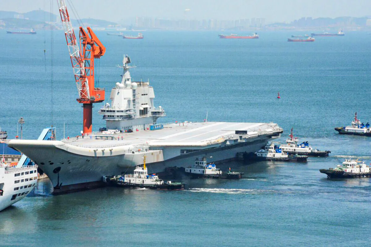 This photo taken on May 18, 2018 shows tugs guiding China's first domestically manufactured aircraft carrier, known as "Type 001A", as it returns to port in Dalian in China's northeastern Liaoning province after its first sea trial.  (AFP via Getty Images)