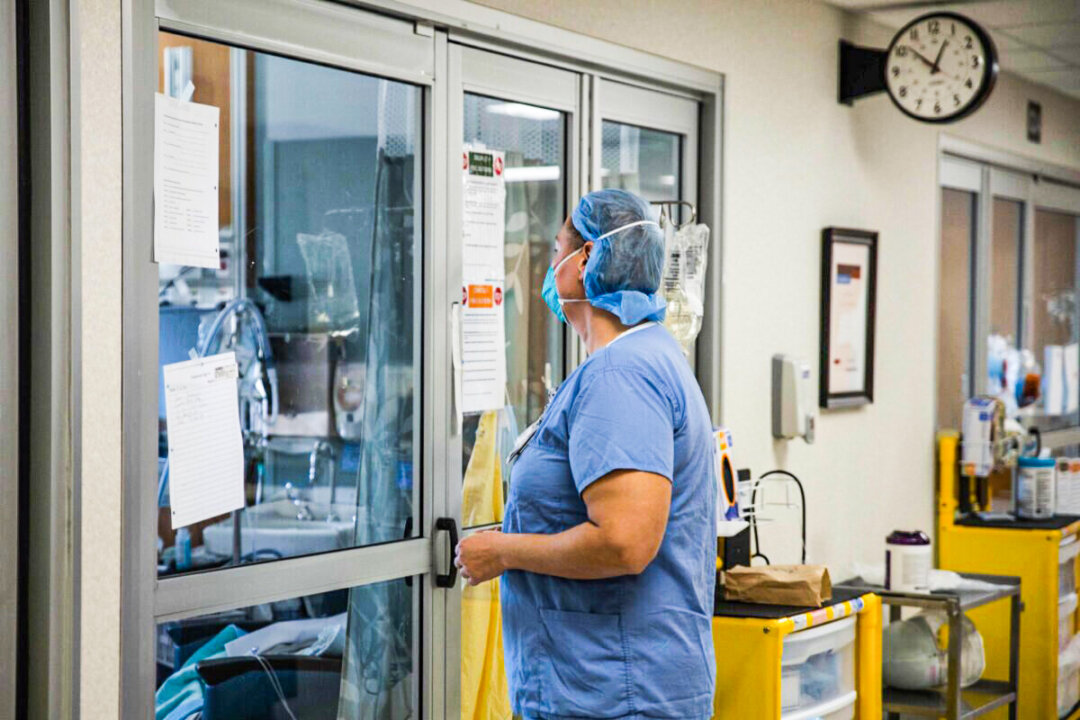 A health care professional prepares to enter a COVID-19 patient's room in a file photo. (Megan Jelinger/AFP via Getty Images) 