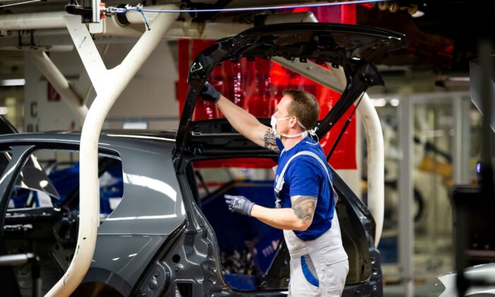 A worker wears a protective mask at the Volkswagen assembly line after VW re-starts Europe's largest car factory after coronavirus shutdown in Wolfsburg, Germany, on April 27, 2020. (Swen Pfoertner/Pool via Reuters)