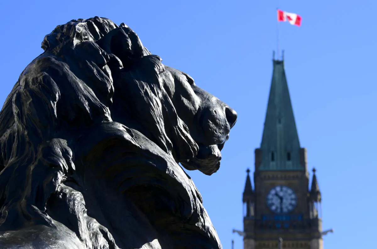 A sculpture of a lion is seen with the Peace Tower in the background on Parliament Hill in Ottawa on April 6, 2020. (The Canadian Press/Sean Kilpatrick)