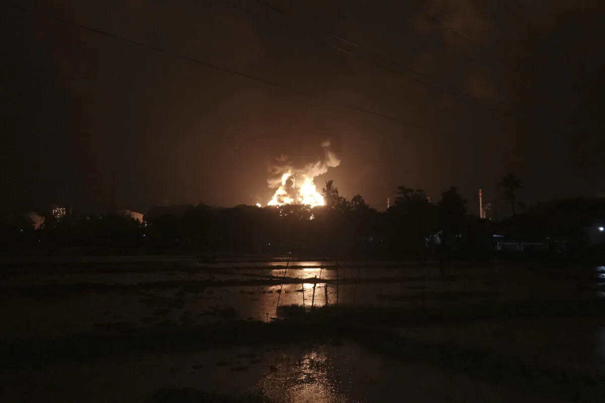 The sky glows from the fire that razes through an oil refinery owned by the national oil company Pertamina in Cilacap, Central Java, Indonesia, on Nov. 13, 2021. (Agus Fitrah/AP Photo)