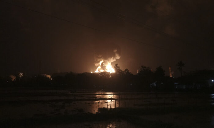 The sky glows from the fire that razes through an oil refinery owned by the national oil company Pertamina in Cilacap, Central Java, Indonesia, on Nov. 13, 2021. (Agus Fitrah/AP Photo)