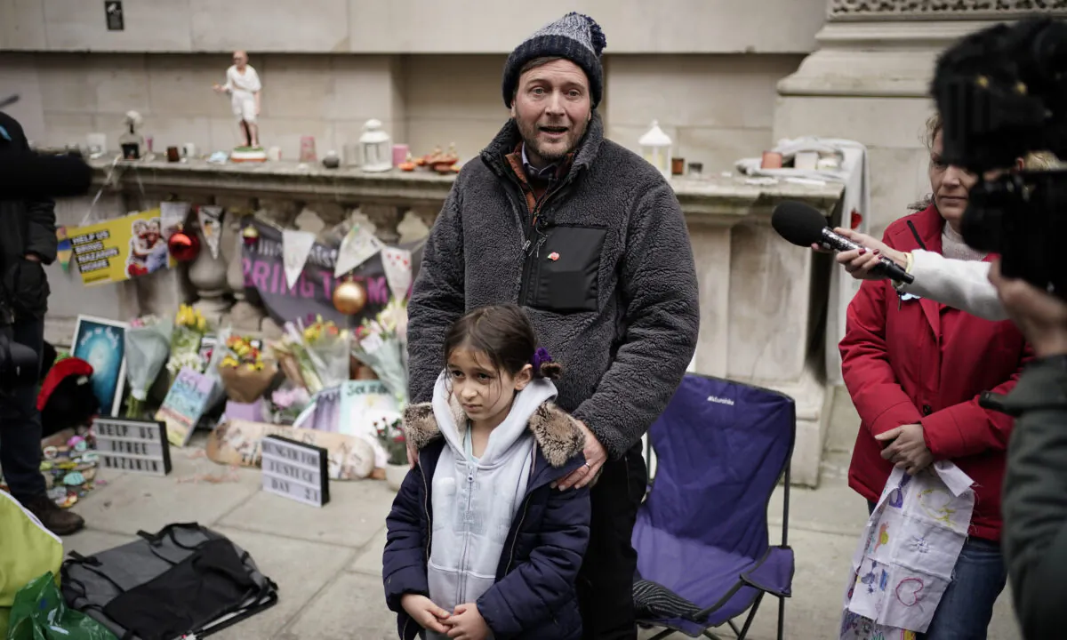 Richard Ratcliffe, the husband of Iranian detainee Nazanin Zaghari-Ratcliffe, with his daughter Gabriella as he ends his 21-day hunger strike outside the Foreign Office in central London on Nov. 13, 2021. (Aaron Chown/PA)
