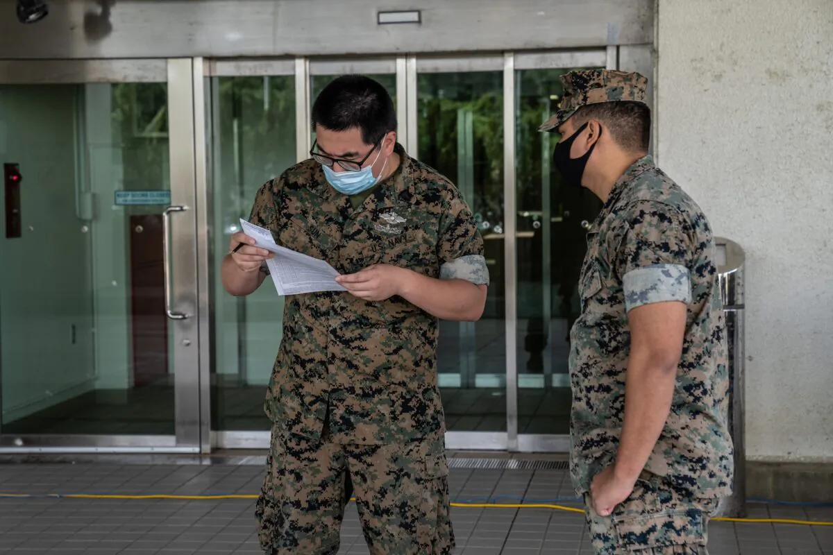 A United States Navy medic checks the documentation of a service member arriving to receive a COVID-19 vaccine in Ginowan, Japan, on April 28, 2021. (Carl Court/Getty Images)
