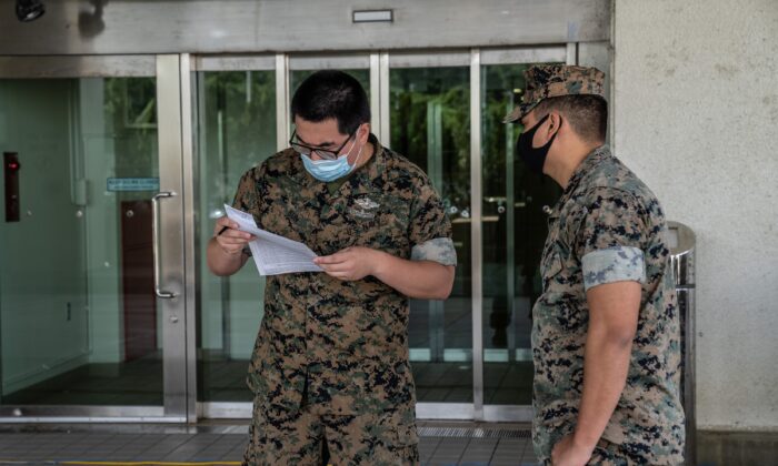 A United States Navy medic checks the documentation of a service member arriving to receive a COVID-19 vaccine in Ginowan, Japan, on April 28, 2021. (Carl Court/Getty Images)