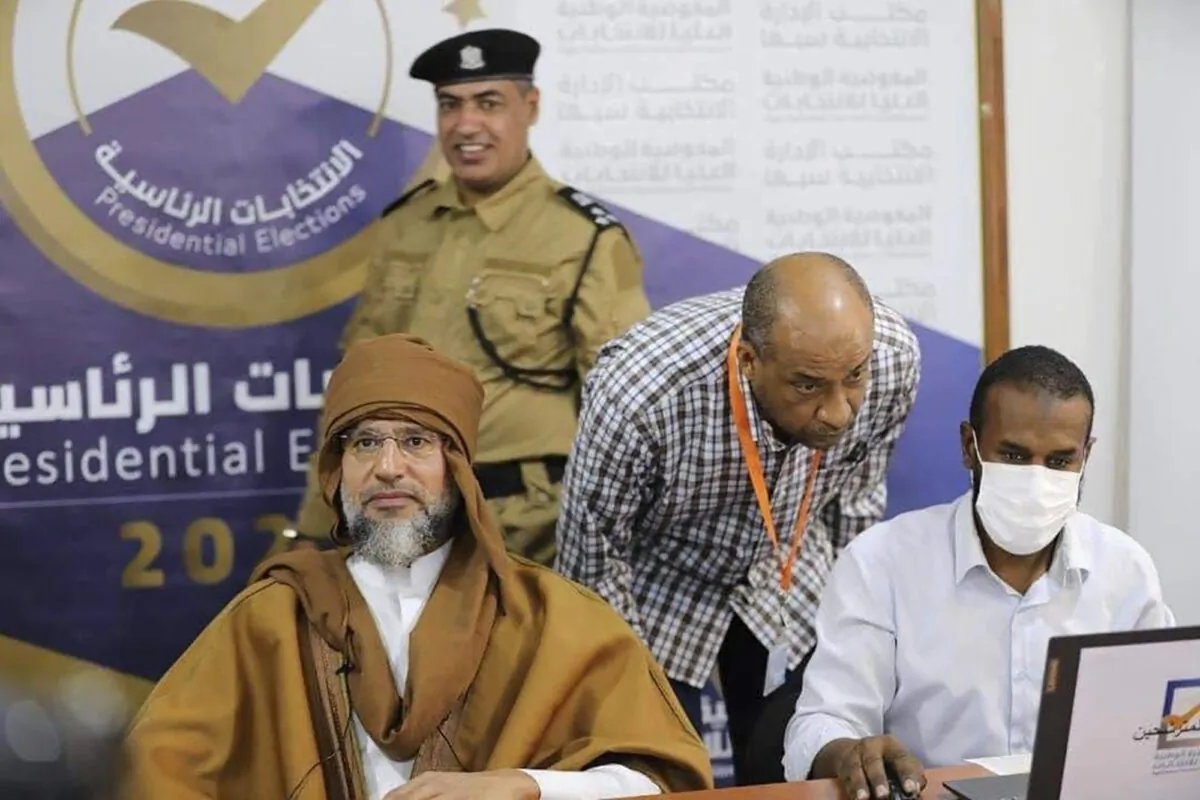 Seif al-Islam (L), the son and one-time heir apparent of late Libyan dictator Moammar Gadhafi, registers his candidacy for the country’s presidential elections next month, in Sabha, Libya, on Nov. 14, 2021. (Libyan High National Elections Commission via AP)