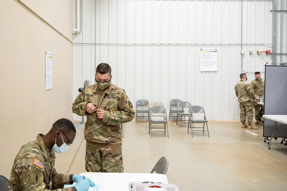 Preventative Medicine Services NCOIC Sergeant First Class Demetrius Roberson prepares to administer a COVID-19 vaccine to a soldier on Sept. 9, 2021 in Fort Knox, Kentucky. (Jon Cherry/Getty Images)