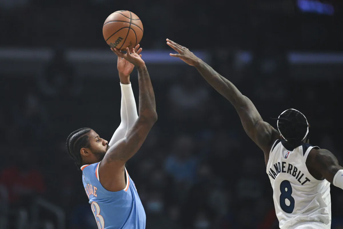 Los Angeles Clippers guard Paul George (13) shoots over Minnesota Timberwolves forward Jarred Vanderbilt (8) during the first half of an NBA basketball game in Los Angeles on Nov. 13, 2021. (AP Photo/Kyusung Gong)