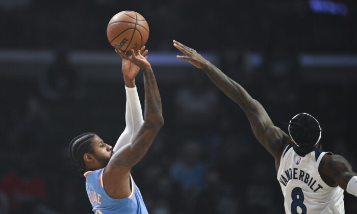 Los Angeles Clippers guard Paul George (13) shoots over Minnesota Timberwolves forward Jarred Vanderbilt (8) during the first half of an NBA basketball game in Los Angeles on Nov. 13, 2021. (AP Photo/Kyusung Gong)