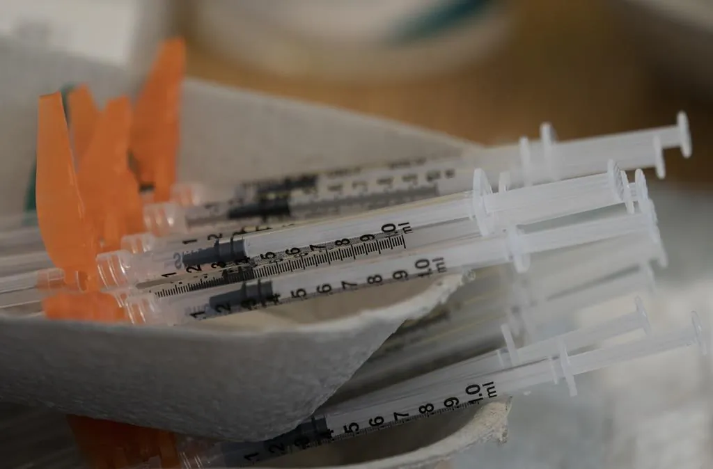 A number of syringes are placed in dishes. (The Canadian Press)