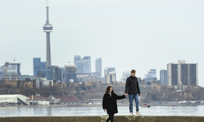 The Toronto city skyline overlooks a calm Lake Ontario on April 5, 2021. (The Canadian Press/Nathan Denette)