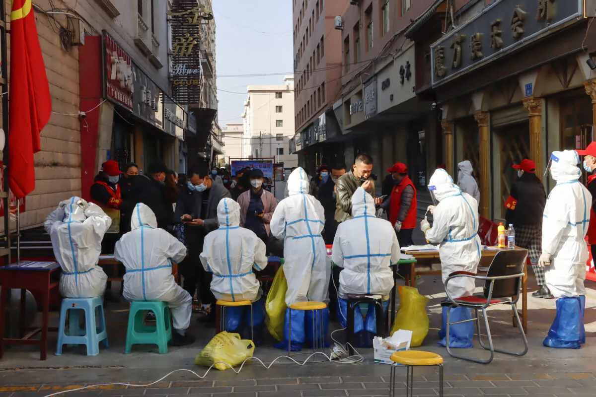 Medical staff members conduct nucleic acid tests for the Covid-19 coronavirus in Zhangye in China's northwestern Gansu Province, on Oct. 23, 2021. (STR/AFP via Getty Images)