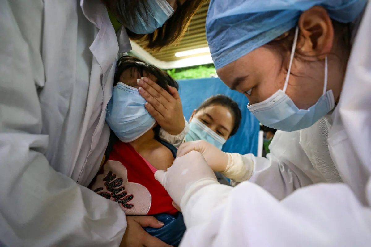 A child receives a COVID-19 coronavirus vaccine in Wuhan, Hubei Province, China, on Nov. 12, 2021. (STR/AFP via Getty Images)