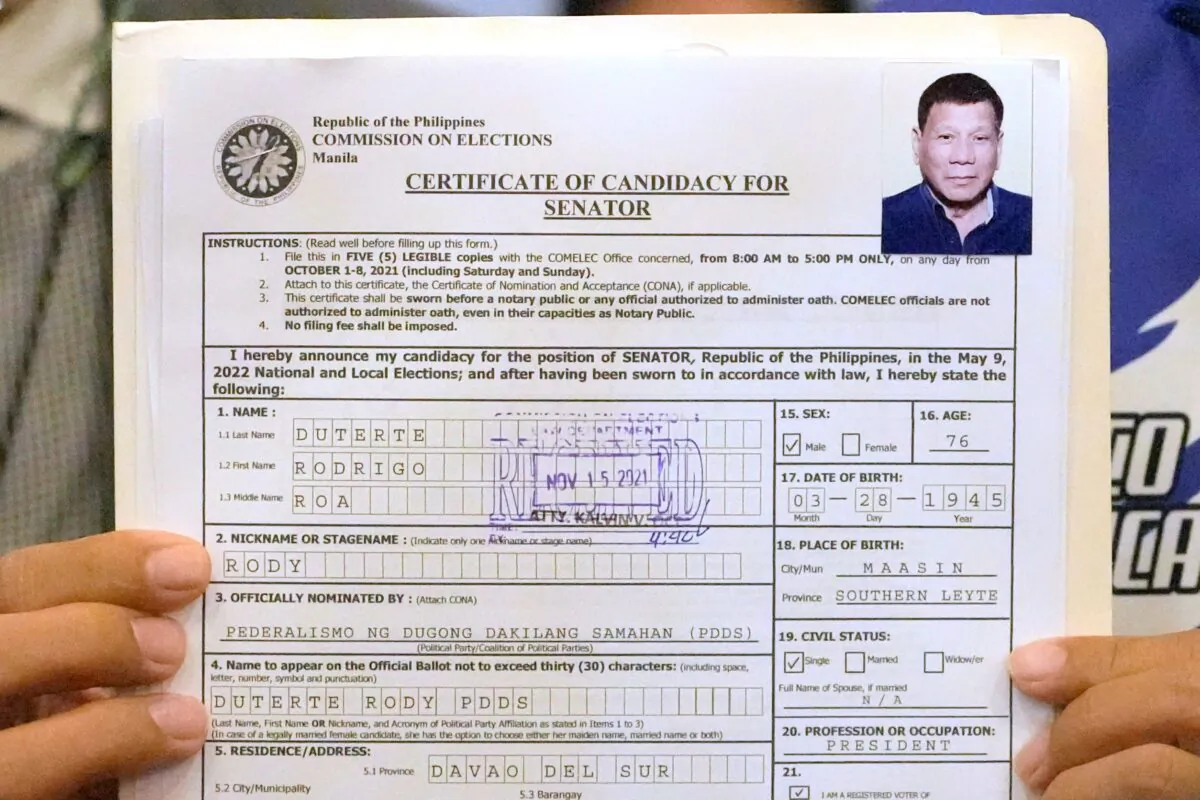 A representative of Philippine President Rodrigo Duterte holds his Certificate of Candidacy for Senator at the Commission on Elections in Manila, Philippines, on Nov. 15, 2021. (Aaron Favila/AP Photo)