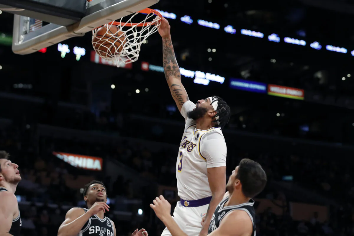 Los Angeles Lakers forward Anthony Davis, second from right, dunks against San Antonio Spurs forward Drew Eubanks, left, guard Devin Vassell, second from left, and forward Doug McDermott, right, during the first half of an NBA basketball game in Los Angeles on Nov. 14, 2021. (AP Photo/Alex Gallardo)