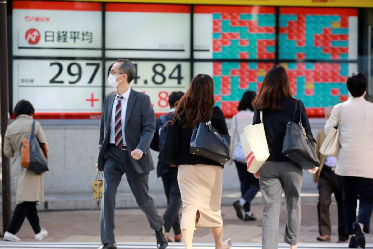 People walk by an electronic stock board of a securities firm in Tokyo, Japan on Nov. 15, 2021. (Koji Sasahara/AP Photo)