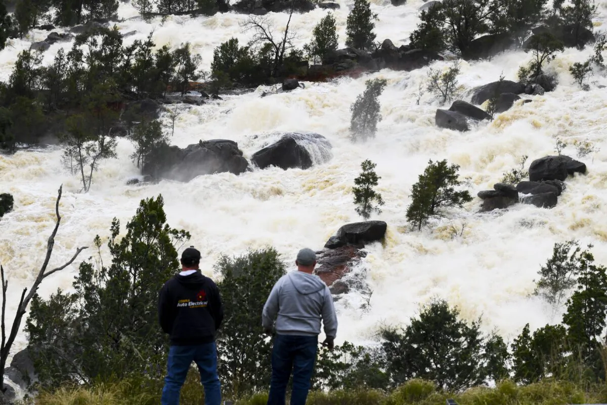 Locals take a look at overflow water spills from Wyangala Dam near the NSW town of Cowra, in Australia, on Nov. 15, 2021. (AAP Image/Lukas Coch) 