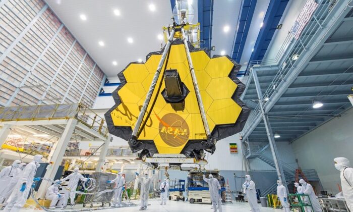 In this 2017 photo, technicians lift the mirror assembly of the James Webb Space Telescope using a crane inside a clean room at NASA's Goddard Space Flight Center in Greenbelt, Md. (NASA via AP/Desiree Stover)