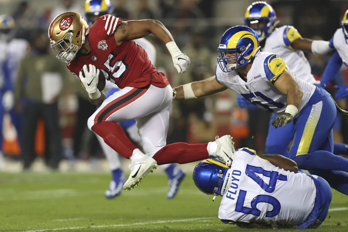 San Francisco 49ers running back Eli Mitchell (25) runs against Los Angeles Rams outside linebacker Leonard Floyd (54) and inside linebacker Troy Reeder (51) during the first half of an NFL football game in Santa Clara, Calif., on Nov. 15, 2021. (AP Photo/Jed Jacobsohn)
