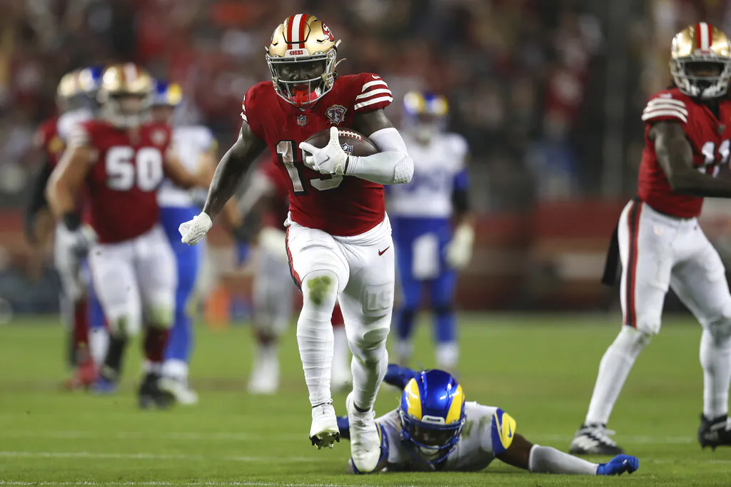 San Francisco 49ers wide receiver Deebo Samuel (19) runs past Los Angeles Rams safety Jordan Fuller to score during the second half of an NFL football game in Santa Clara, Calif., on Nov. 15, 2021. (Jed Jacobsohn/AP Photo)