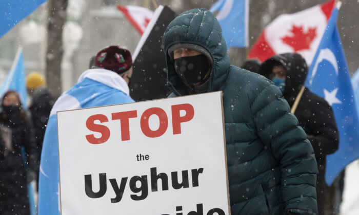 Demonstrators gather outside the Parliament buildings in Ottawa during a protest against Uyghur genocide on Feb. 22, 2021. (Adrian Wyld/The Canadian Press)
