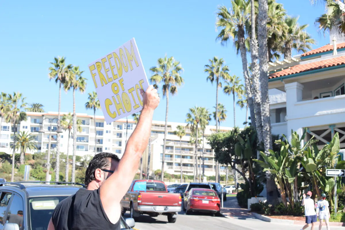 Parents and children gather at the San Clemente Pier for a statewide "Sit and Rally" demonstration to protest California's COVID-19 vaccine requirements for K–12 students in San Clemente, Calif., on Nov. 15, 2021. (Brandon Drey/The Epoch Times)
