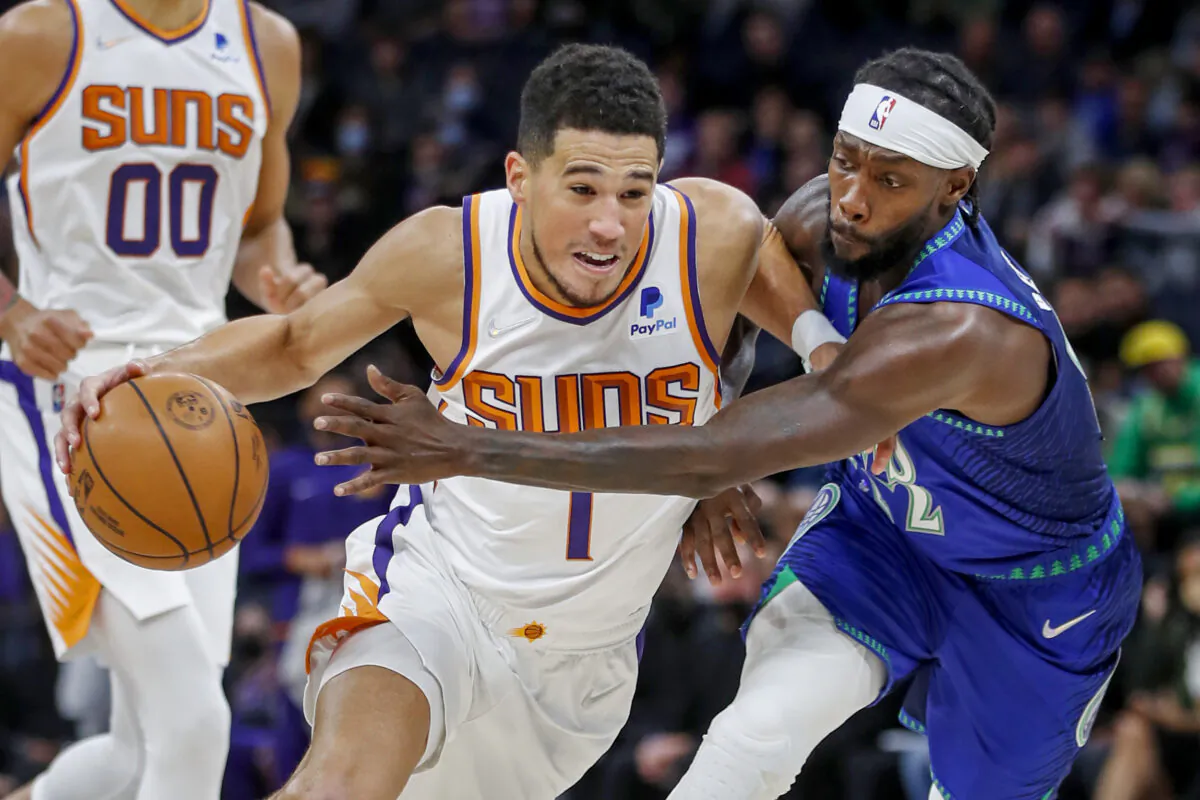 Phoenix Suns guard Devin Booker (1) works around Minnesota Timberwolves guard Patrick Beverley (22) in the first quarter of an NBA basketball game in Minneapolis, Minn., on Nov. 15, 2021. (Bruce Kluckhohn/AP Photo)