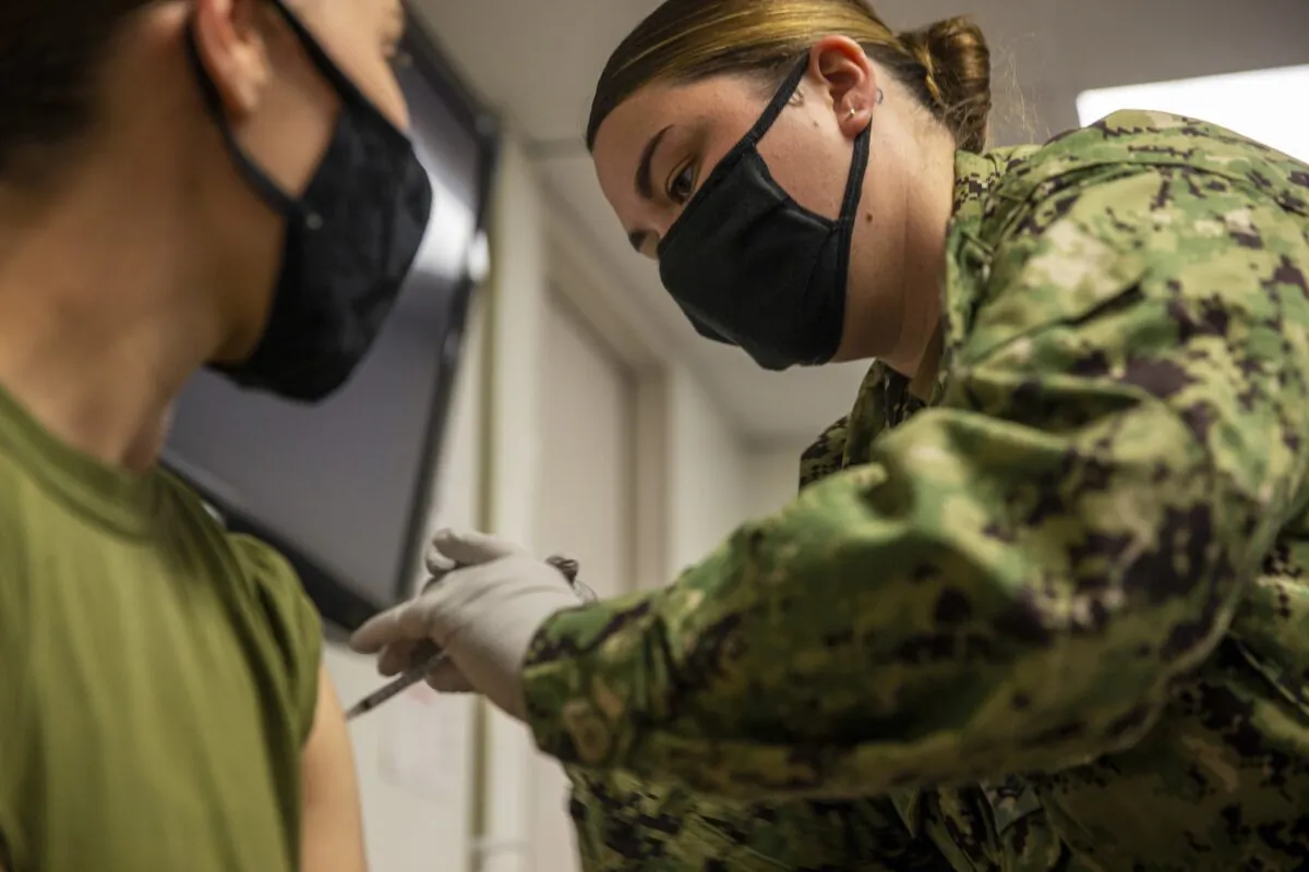 A Navy petty officer gives a Marine a COVID-19 vaccine on Camp Pendleton, Calif., on Sept. 22, 2021. (U.S. Marine Corps photo by Cpl. Andrew Cortez via The Epoch Times)