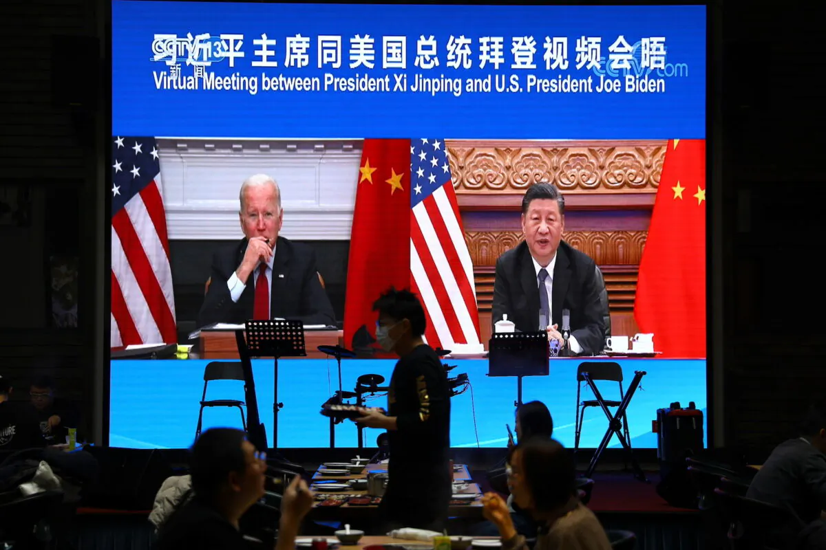 A screen shows Chinese leader Xi Jinping attending a virtual meeting with U.S. President Joe Biden via video link, at a restaurant in Beijing, China, on Nov. 15, 2021. (Tingshu Wang/Reuters)