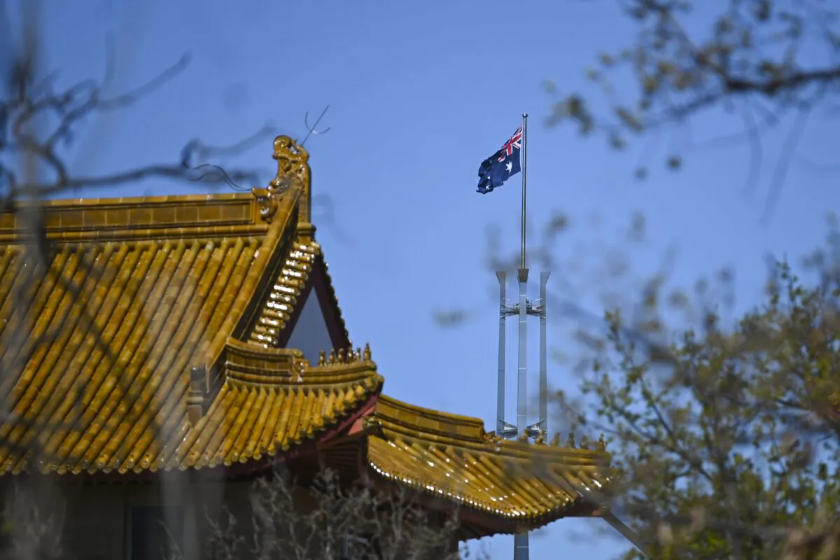 The flag pole of the Australian Parliament is seen behind the roof of the Chinese Embassy in Canberra, on Sept. 17, 2021. (AAP Image/Lukas Coch)