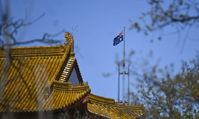 The flag pole of the Australian Parliament is seen behind the roof of the Chinese Embassy in Canberra, on Sept. 17, 2021. (AAP Image/Lukas Coch)
