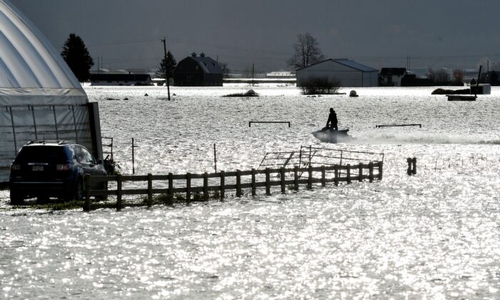 A person riding a Sea-Doo passes through a flooded farm after rainstorms caused flooding and landslides in Abbotsford, British Columbia, Canada on Nov. 16, 2021. (Jennifer Gauthier/Reuters)