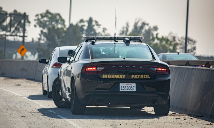 A California Highway Patrol officer pulls someover over on the 405 Freeway in Los Angeles, Calif., on Nov. 8, 2021. (John Fredricks/The Epoch Times)