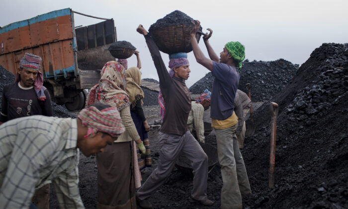 Workers load coal onto a truck at a coal depot near Lad Rymbai, in the district of East Jaintia Hills, India, on April 14, 2011. Daniel Berehulak/Getty Images