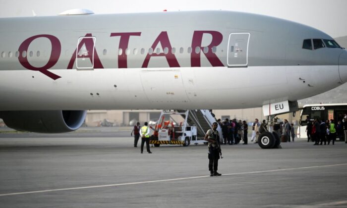 A Qatari security personnel stands guard as passengers board a Qatar Airways aircraft bound to Qatar at the airport in Kabul, Afghanistan, on Sept. 10, 2021. (Aamir Qureshi/AFP via Getty Images)