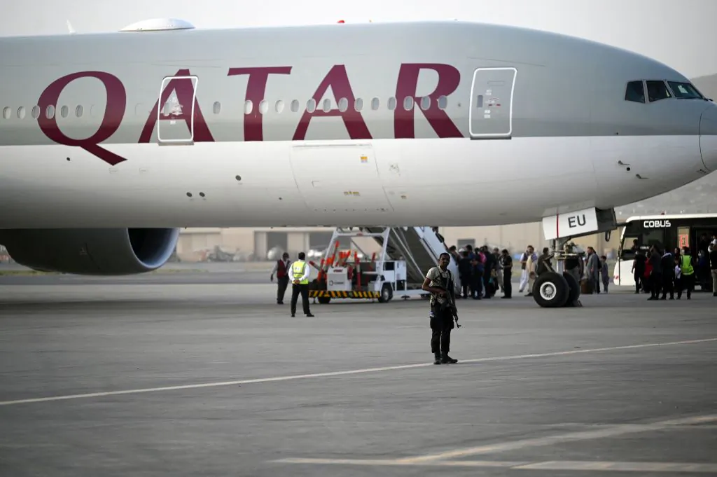 A Qatari security personnel stands guard as passengers board a Qatar Airways aircraft bound to Qatar at the airport in Kabul, Afghanistan, on Sept. 10, 2021. (Aamir Qureshi/AFP via Getty Images)