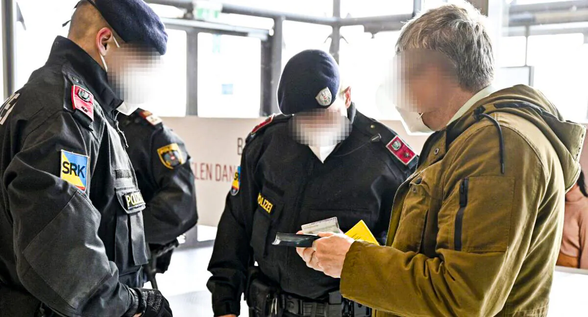 Austrian police officers check a man's identity and vaccination certificate during a control in Voesendorf, district Moedling, Austria, on November 16, 2021 (HANS PUNZ/APA/AFP via Getty Images)